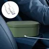 A green electric lunchbox is placed on the car seat, connected to a white USB cable. Produktbild-Vorschau