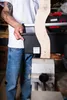 A person is holding a black toolbox in a workshop setting. Voir les images du produit
