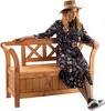 A woman is sitting on a wooden park bench. Produktbild-Vorschau