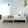 A white wooden bed frame with a white mattress and grey blanket in a minimalist bedroom. Náhled obrázku produktu