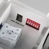 Close-up view of internal components of a light fixture, showing a DIP switch and wire connectors. Náhľad obrázku produktu