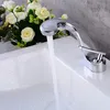 A chrome faucet is running water into a white sink, with a bouquet of white flowers in the background. Podgląd zdjęcia produktu