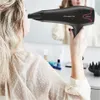 A woman is drying her hair with a hairdryer in front of a mirror. Anteprima dell’immagine prodotto
