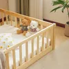 A wooden crib with two teddy bears and a pillow inside. Produktbild-Vorschau