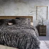 A bedroom scene with a bed dressed in paisley patterned bedding. Produktbild-Vorschau