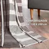 A striped blanket draped over a floor and partially covering a piece of furniture. Produktbild-Vorschau
