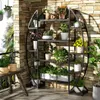 A multi-tiered plant stand filled with various potted plants, displayed on a balcony with a stone wall background. Podgląd zdjęcia produktu