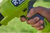 A hand is holding a green and gray power tool. Produktbild-Vorschau