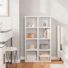 A white cube shelf unit with items on display, next to a vanity and a bed. Produktbild-Vorschau