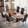 A dining room scene with a wooden table and six black chairs. Náhľad obrázku produktu