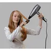 A woman is drying her hair with a hairdryer and a brush. Anteprima dell’immagine prodotto