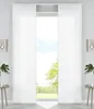 A pair of white panel curtains are drawn open, revealing a view of trees and sky through a window. Produktbild-Vorschau
