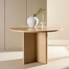 A round wooden table with a vase and a candle on it, set against a neutral background. Voir les images du produit