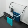 A white wire drying rack with four towels hanging on it, attached to a white radiator. Podgląd zdjęcia produktu