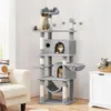 A multi-level cat tree with several cats on it, placed in a living room setting next to a sofa and a cabinet. Produktbild-Vorschau