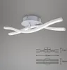 A modern LED ceiling light with a silver base and two intertwined white light strips, shown against a plain gray background. A technical diagram with dimensions is also visible in the lower right corner. Produktbild-Vorschau