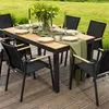 An outdoor dining set with a table and chairs on a wooden deck, surrounded by grass. Produktbild-Vorschau