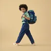 A young boy wearing a backpack walks forward against a plain background. Voir les images du produit