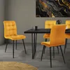 A dining room scene with four yellow velvet chairs around a black dining table. Náhled obrázku produktu