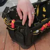 A hand is reaching into a black and yellow Stanley FatMax tool bag, which is filled with various tools and is placed on a wooden floor. Anteprima dell’immagine prodotto