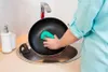 A person is washing a pan in a kitchen sink. Anteprima dell’immagine prodotto