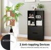 A black bookshelf with two drawers and four open shelves, displayed in a room with a potted plant and wall art. Two instructional graphics about anti-toppling devices are overlaid on the plant. Podgląd zdjęcia produktu
