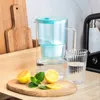 A water filter pitcher with a glass and lemons on a wooden counter. Náhled obrázku produktu