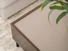 A close-up view of a coffee table with a plant on it, next to a sofa. Náhled obrázku produktu