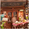 A miniature diorama of a coffee shop facade with tables and chairs set up outside. Podgląd zdjęcia produktu