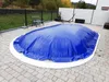 An oval-shaped inflatable pool cover is shown on a paved patio area. Produktbild-Vorschau
