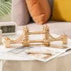 A wooden model of the Tower Bridge sits on a table next to a digital clock and a magazine. Anteprima dell’immagine prodotto