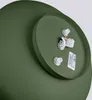 A close-up view of the underside of a green ceiling light fixture, showing the electrical connection components and a label. Produktbild-Vorschau