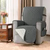 A gray recliner chair with a protective cover, placed next to a wooden side table with flowers. Anteprima dell’immagine prodotto