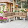 An outdoor patio area with a sectional sofa made from white painted wooden pallets and beige cushions, surrounded by potted plants and a covered seating area. Anteprima dell’immagine prodotto