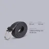 A coiled gray fabric belt with a silver buckle is shown next to a size chart. Anteprima dell’immagine prodotto