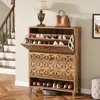 A wooden shoe cabinet with shoes and a handbag, placed near a staircase and a lamp. Podgląd zdjęcia produktu