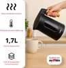 A hand pours water from a black electric kettle into a white mug on a wooden countertop. Produktbild-Vorschau