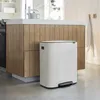 A white Brabantia Bo Mülleimer with a pedal is placed next to a kitchen island with wooden cabinets. Náhľad obrázku produktu