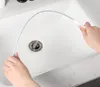 A person is cleaning a sink drain with a flexible brush. Produktbild-Vorschau
