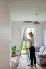 A woman is using a ladder in a living room. Anteprima dell’immagine prodotto
