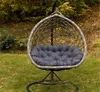 A hanging egg chair with a dark gray cushion sits on a grassy lawn with fallen leaves and trees in the background. Produktbild-Vorschau
