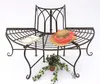 A metal garden bench with a book and a hat on it, with a potted plant and ivy at its base. Náhled obrázku produktu
