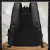 The back of a black rucksack is shown against a marbled background with gold accents. Produktbild-Vorschau