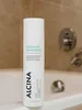 A bottle of shampoo is placed on the edge of a bathtub, with a shower faucet visible in the background. Produktbild-Vorschau