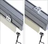 Close-up of a roller blind mechanism attached to a gray track, with a beige fabric roller blind partially extended. Produktbild-Vorschau