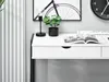 A close-up view of a white desk with a black frame, featuring a black lamp, a potted plant, and an open magazine. Voir les images du produit
