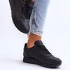 A person wearing ripped jeans and black sneakers. Produktbild-Vorschau