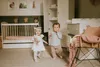 A nursery room with two babies playing near a crib and a wardrobe. Produktbild-Vorschau