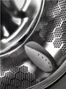 Close-up view of the inside of a washing machine drum, showing a cleaning accessory. Produktbild-Vorschau