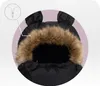 Close-up view of a black stroller footmuff with a fur-lined hood and bear ears. A diagram of a zipper is shown in the upper left corner. Náhled obrázku produktu